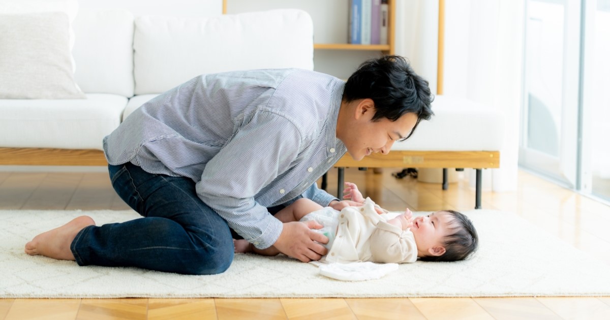 便秘の赤ちゃんのおむつ替えをするパパ